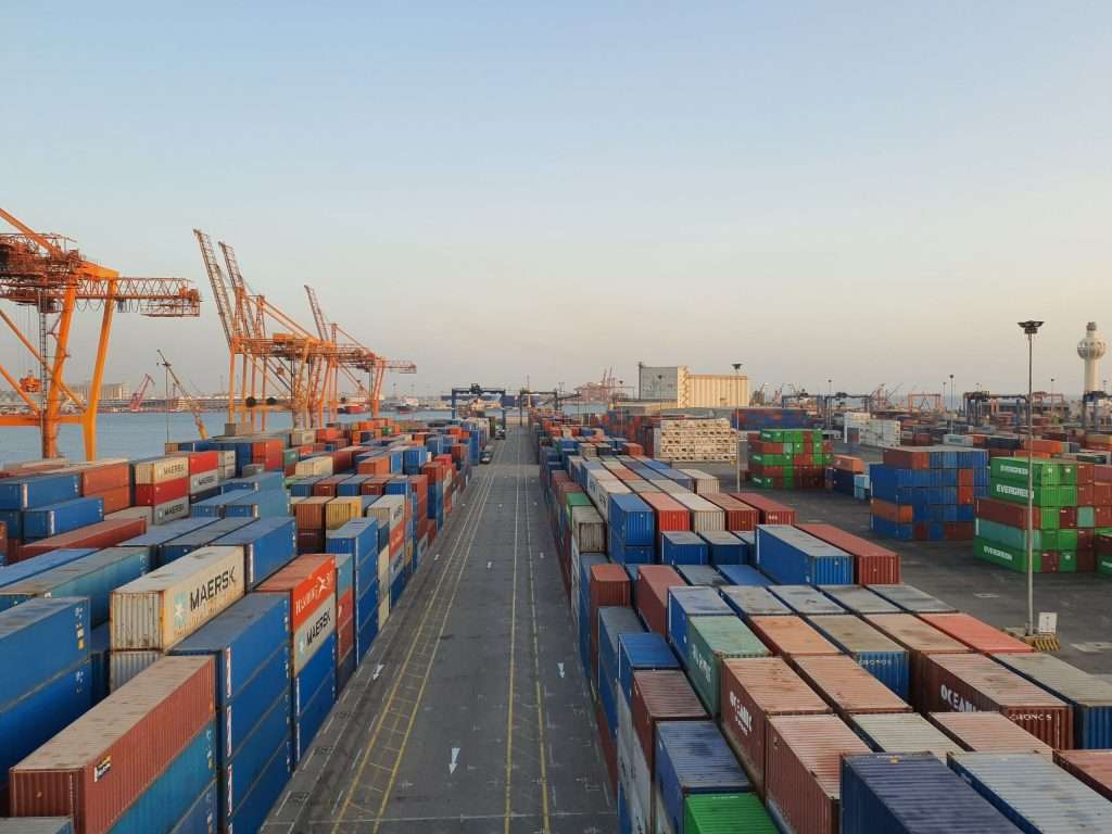 Colourful cargo containers stacked at a harbour at sunrise