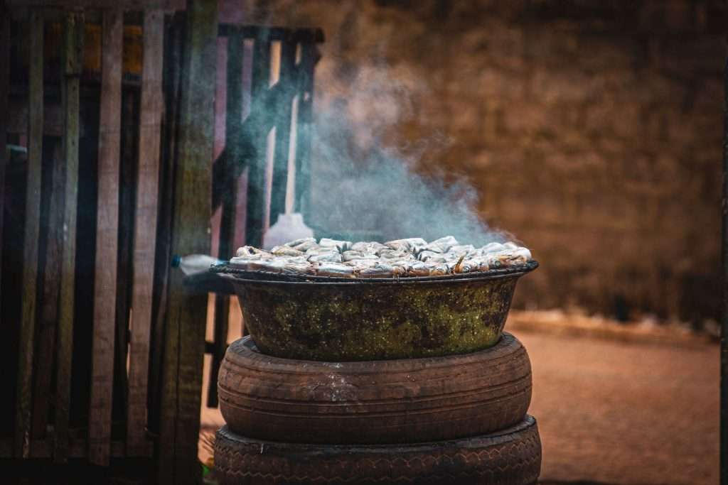 Fish being smoked outdoors using traditional methods in Africa
