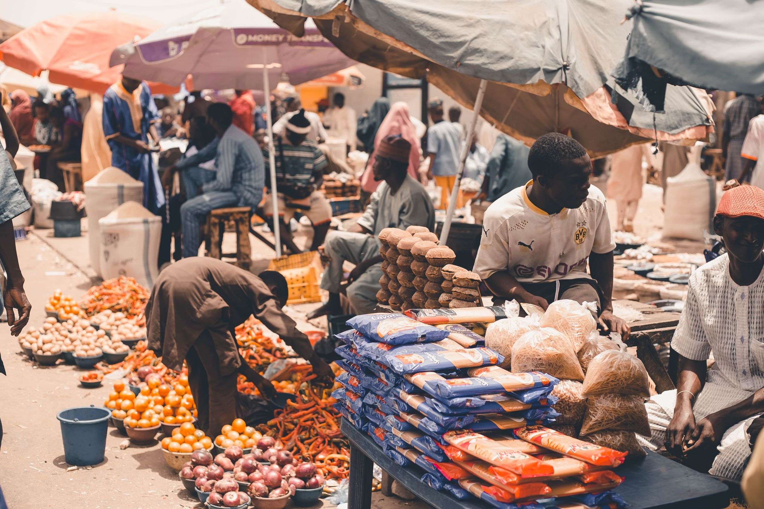 Local market scene with fresh produce and vendors under umbrellas