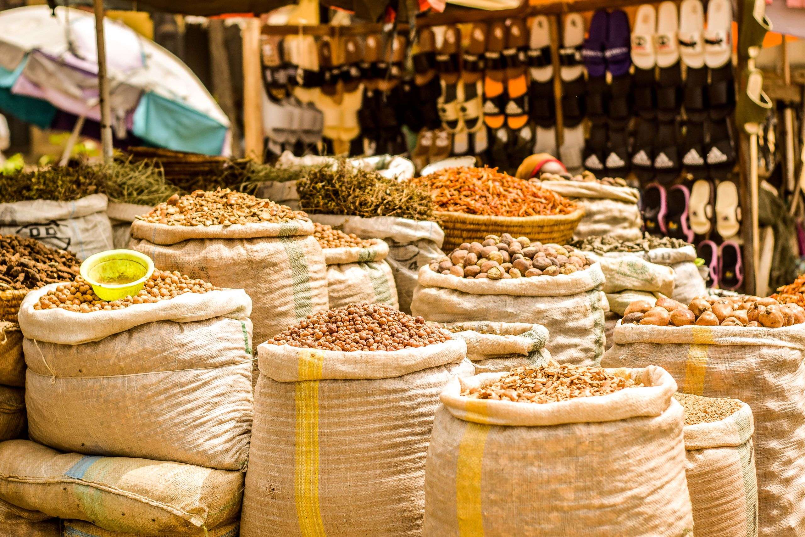 Bags of colourful seeds and spices displayed at an outdoor African market