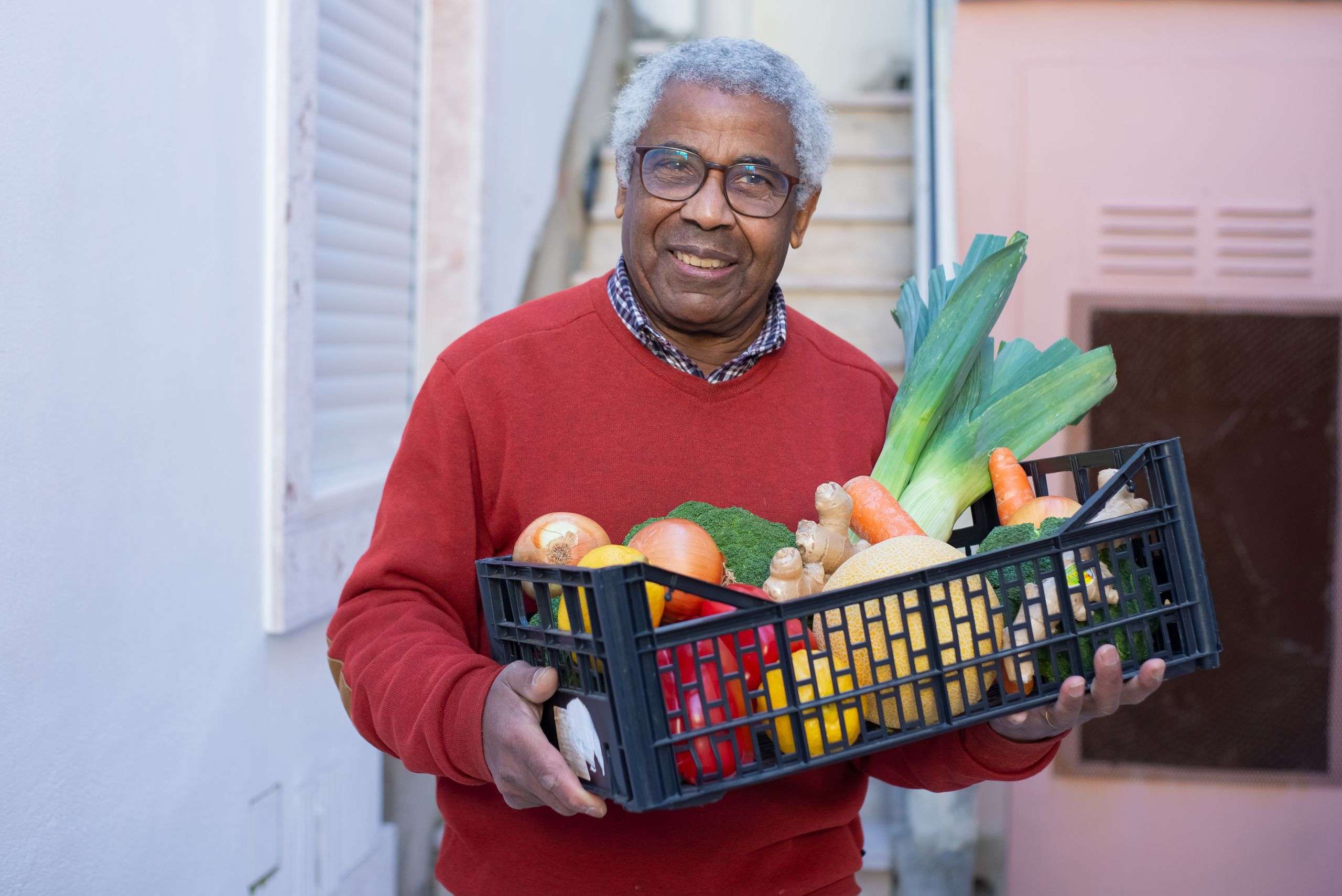 Man carrying a crate of fresh vegetables